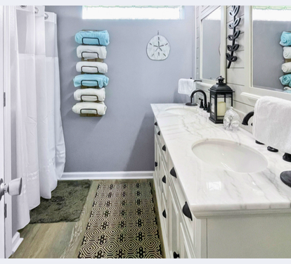 Step into your spa-like bathroom with marble countertops, soft towels, and coastal decor that creates a serene retreat for your morning routine.