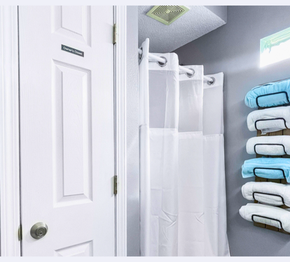 Step into your pristine bathroom where fluffy towels await on stylish wall racks, and fresh linens make every shower feel luxurious.