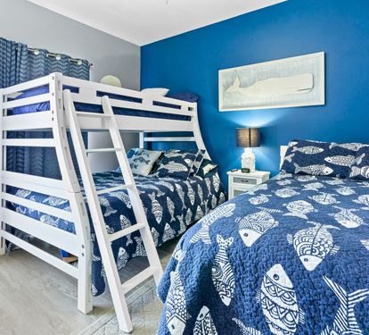 Drift off in this ocean-themed bedroom where nautical blues wrap you in seaside serenity and cozy bedding promises restful nights.