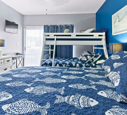 Your family bedroom features a king bed and bunk bed with nautical-themed bedding, creating the perfect space for everyone to rest comfortably.