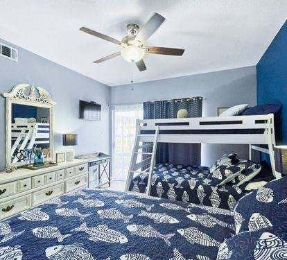 Drift off to sleep in this coastal-themed bedroom featuring comfortable beds and a charming bunk bed perfect for family adventures.