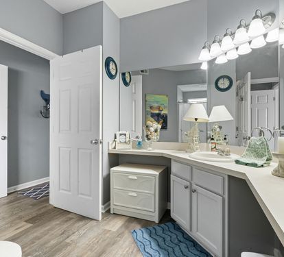 Step into your spacious bathroom featuring elegant gray cabinetry, granite countertops, and coastal-themed touches that create a serene coastal retreat atmosphere.