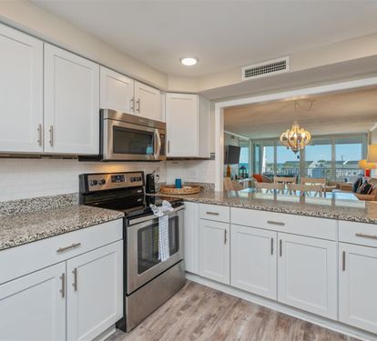 Cook with ease in your fully equipped kitchen, featuring granite counters and stainless appliances while enjoying ocean views.
