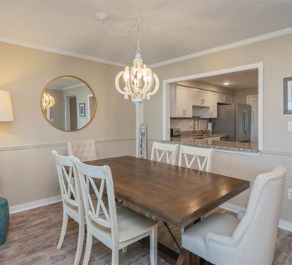 Gather around your elegant dining table for memorable meals, with warm pendant lighting and an open view to your fully-equipped kitchen.