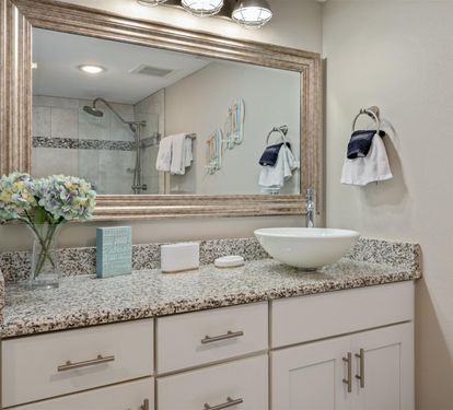 Your elegant bathroom features granite counters, vessel sink, and coastal touches that make your morning routine feel like a spa retreat.