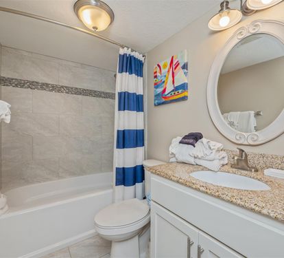 Your private bathroom features a relaxing tub-shower combo with nautical touches and fresh towels waiting for your arrival.