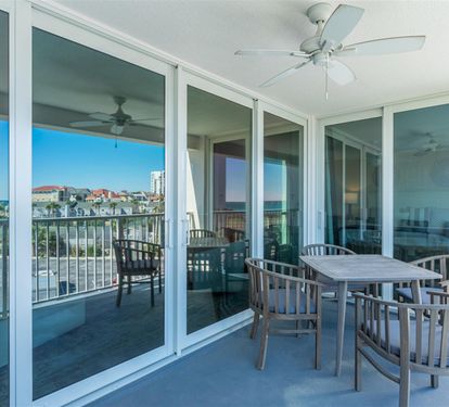 Your covered balcony offers coastal comfort with dining space and sweeping views of the charming neighborhood below.