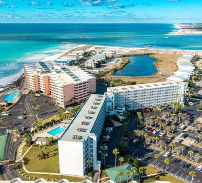 Aerial view of beachfront resort complex with stunning turquoise waters and pristine white sand beaches stretching along the Gulf Coast.