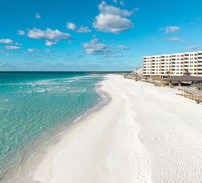 Stunning beachfront location with pristine white sand and crystal-clear emerald waters stretching endlessly along the coast.