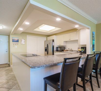 Your sleek kitchen island beckons with granite countertops and breakfast bar seating, perfectly positioned beneath elegant recessed lighting.