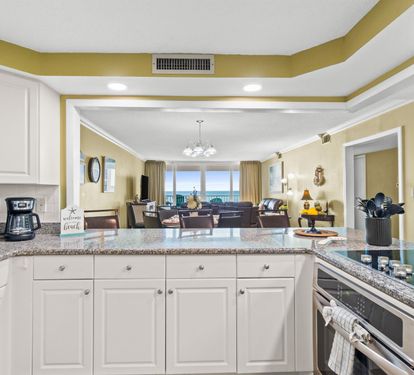 Your fully equipped kitchen features granite countertops and opens to a spacious living area with stunning ocean views.