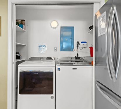 Your private laundry closet features full-size washer and dryer with convenient shelving for supplies.