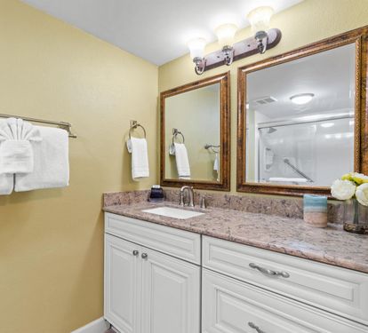 Your spacious bathroom features elegant granite countertops, warm lighting, and thoughtful touches like fresh flowers to make your stay feel special.