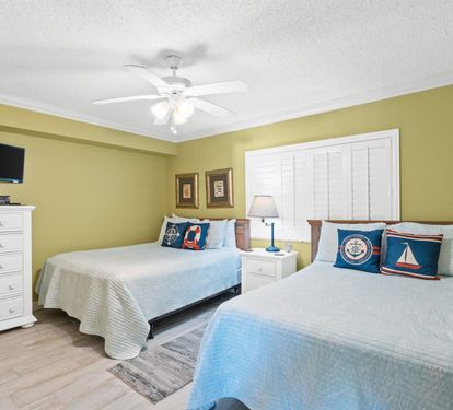 Settle into your coastal-themed bedroom with two comfortable beds, gentle ceiling fan, and nautical touches that create the perfect seaside retreat.