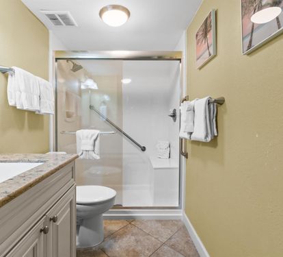 Step into your spacious bathroom featuring elegant granite countertops, a refreshing glass-enclosed shower, and plush towels awaiting your arrival.