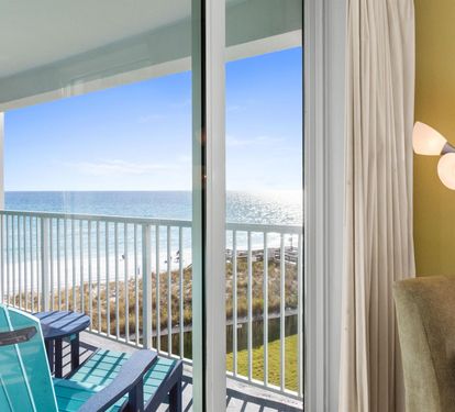 Your private balcony opens to breathtaking ocean views where turquoise chairs await your morning coffee moments.