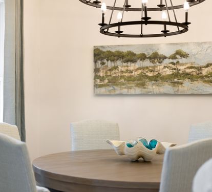 Your elegant dining space features a round table perfect for intimate meals, complemented by soft natural light.
