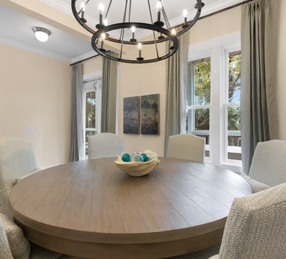 Gather around your elegant dining table for memorable meals, illuminated by stylish chandelier lighting and surrounded by comfortable seating.