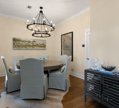 Gather around your elegant dining table beneath the stunning chandelier for memorable meals together.