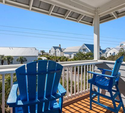 Sip your morning coffee in these cheerful blue Adirondack chairs while soaking up coastal charm and neighborhood views.