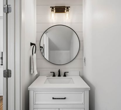 Step into your stylish bathroom featuring a sleek round mirror, elegant vanity, and modern fixtures that create the perfect morning routine space.