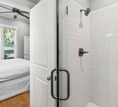 Unwind in your elegant ensuite with a sleek glass shower featuring white subway tiles and modern fixtures.