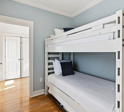 Rest easy in your cozy bunk room with fresh linens and soothing blue walls creating the perfect retreat.
