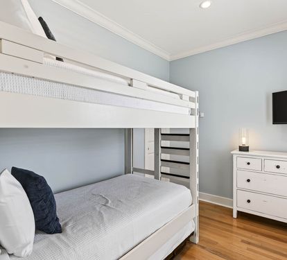 Your family will love this charming bunk room with soft linens, warm hardwood floors, and entertainment ready for cozy evenings together.