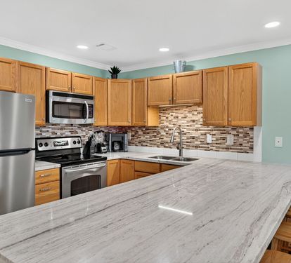 Your fully-equipped kitchen features granite countertops, stainless steel appliances, and a convenient breakfast bar where you can enjoy morning coffee or prepare meals together.