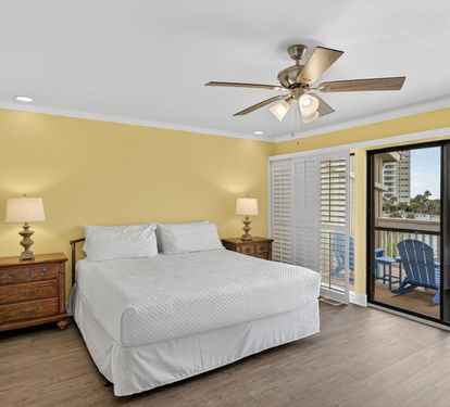 Unwind in your bright, cheerful bedroom with comfortable bedding, ceiling fan for gentle breezes, and sliding doors opening to your private balcony.