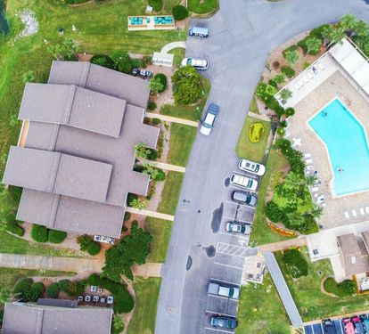 Aerial view of the neighborhood. Community pool directly across the parking lot from the unit.