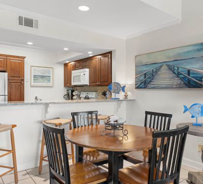 Your fully equipped kitchen and dining space invites memorable meals with ocean-inspired art setting the perfect coastal mood.