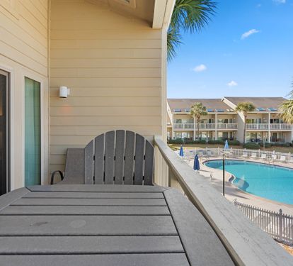Relax on your private balcony with stunning pool views and tropical palms framing the perfect vacation backdrop.