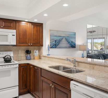 Your fully-equipped kitchen features granite countertops, rich wood cabinets, and stainless steel appliances, perfect for preparing meals while enjoying the open living space.