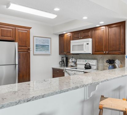 Your fully equipped kitchen features rich wood cabinets, granite counters, and stainless appliances—perfect for preparing meals during your stay.