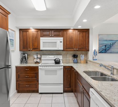 Your fully equipped kitchen features rich wood cabinetry, granite countertops, and modern stainless appliances for memorable meal preparation.