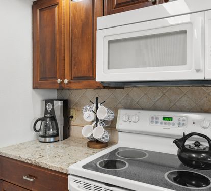 Your fully equipped kitchen features granite counters, warm wood cabinets, and everything needed to prepare meals during your stay.