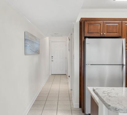 Your sleek kitchen features premium stainless steel appliances and rich wood cabinetry, with marble countertops perfect for meal prep.