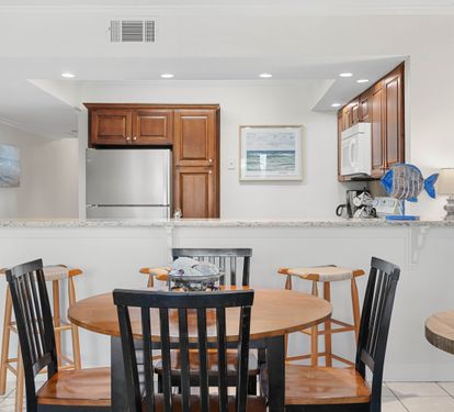 Gather around your spacious dining table while meals simmer in the fully-equipped kitchen, where ocean-inspired artwork creates a serene coastal atmosphere.