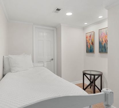 Rest peacefully in your cozy bedroom featuring crisp white linens, vibrant artwork, and thoughtful touches that make this space feel like home.
