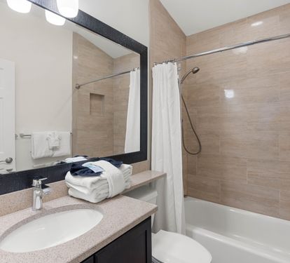 Step into your spotless bathroom featuring a soothing tub-shower combo, perfect for unwinding after exploring.