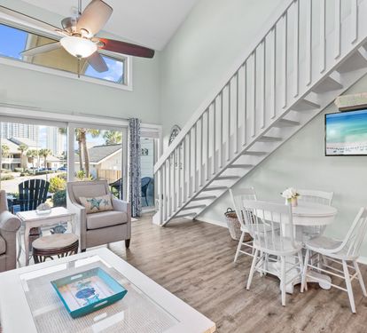 Bright and airy coastal retreat featuring soaring ceilings, an open-concept layout, and relaxing beach-inspired décor perfect for gathering, dining, and unwinding after a day at the beach.