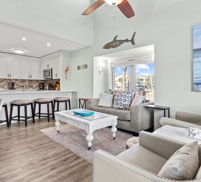 Bright coastal living area with an open layout, comfortable seating, and a beautifully updated kitchen perfect for relaxing, gathering, and making vacation memories.