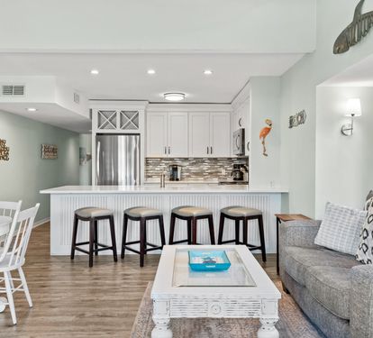 Beautifully updated kitchen and living space with coastal-inspired finishes, bar seating, and an open layout designed for relaxing and spending quality time together.