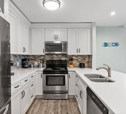 Fully updated coastal kitchen featuring stainless steel appliances, modern finishes, and a functional open layout perfect for preparing meals and gathering with family and friends.