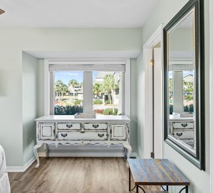 Relax in the inviting primary bedroom featuring coastal-inspired décor, comfortable furnishings, and a peaceful atmosphere perfect for unwinding after a day at the beach.