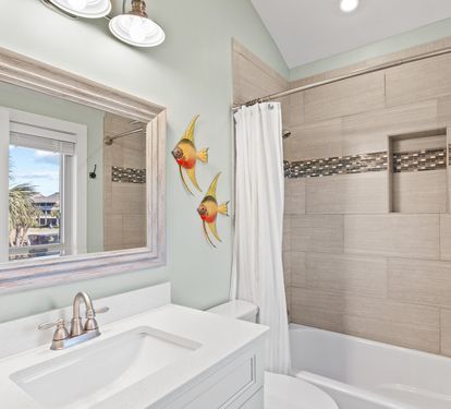 Bright and updated guest bathroom with coastal-inspired finishes, a tiled tub and shower combo, and a clean, relaxing design for your comfort and convenience.