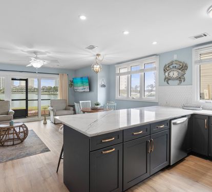 Spacious open layout with quartz countertops, navy cabinets, and lake views from the kitchen—perfect for entertaining and relaxing in style.