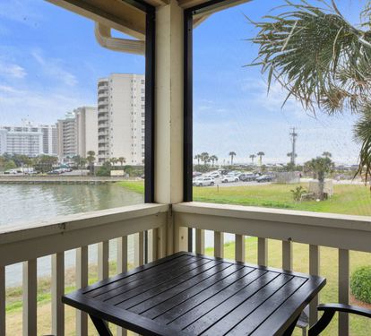 Enjoy serene lake and partial Gulf views from this cozy screened balcony, complete with a bistro table—ideal for relaxing in the coastal breeze.