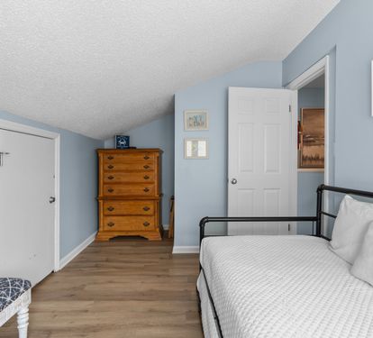 This versatile guest loft features a cozy daybed that converts to a king, wood flooring, and a classic chest of drawers—ideal for kids or extra guests.